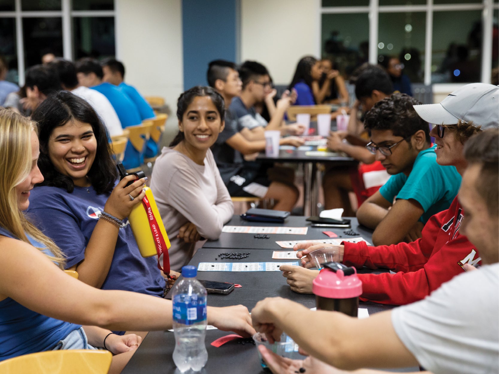 A group of UMD students play BINGO at a long table in STMAP