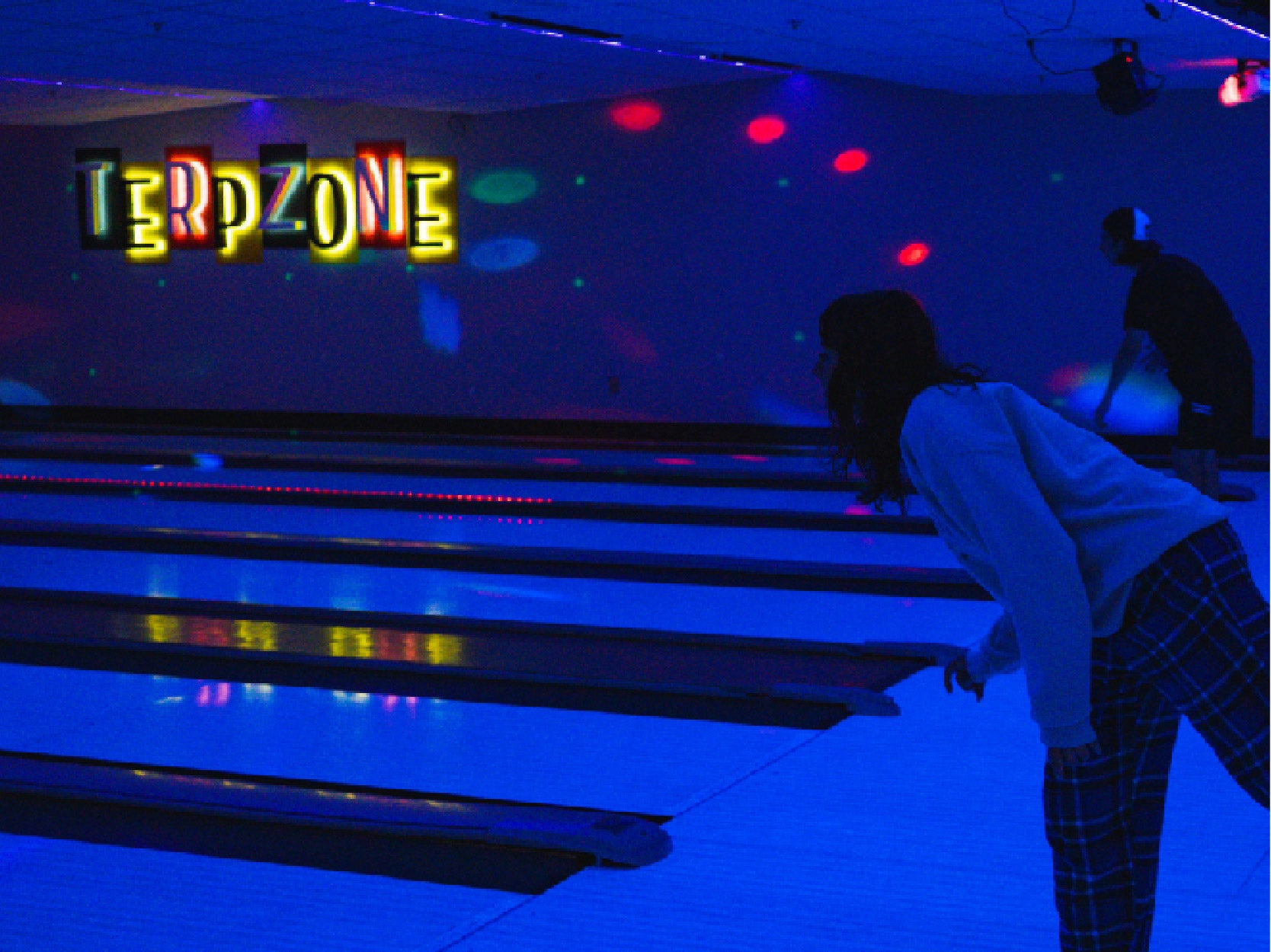 UMD students bowl under black lights in the TerpZone.