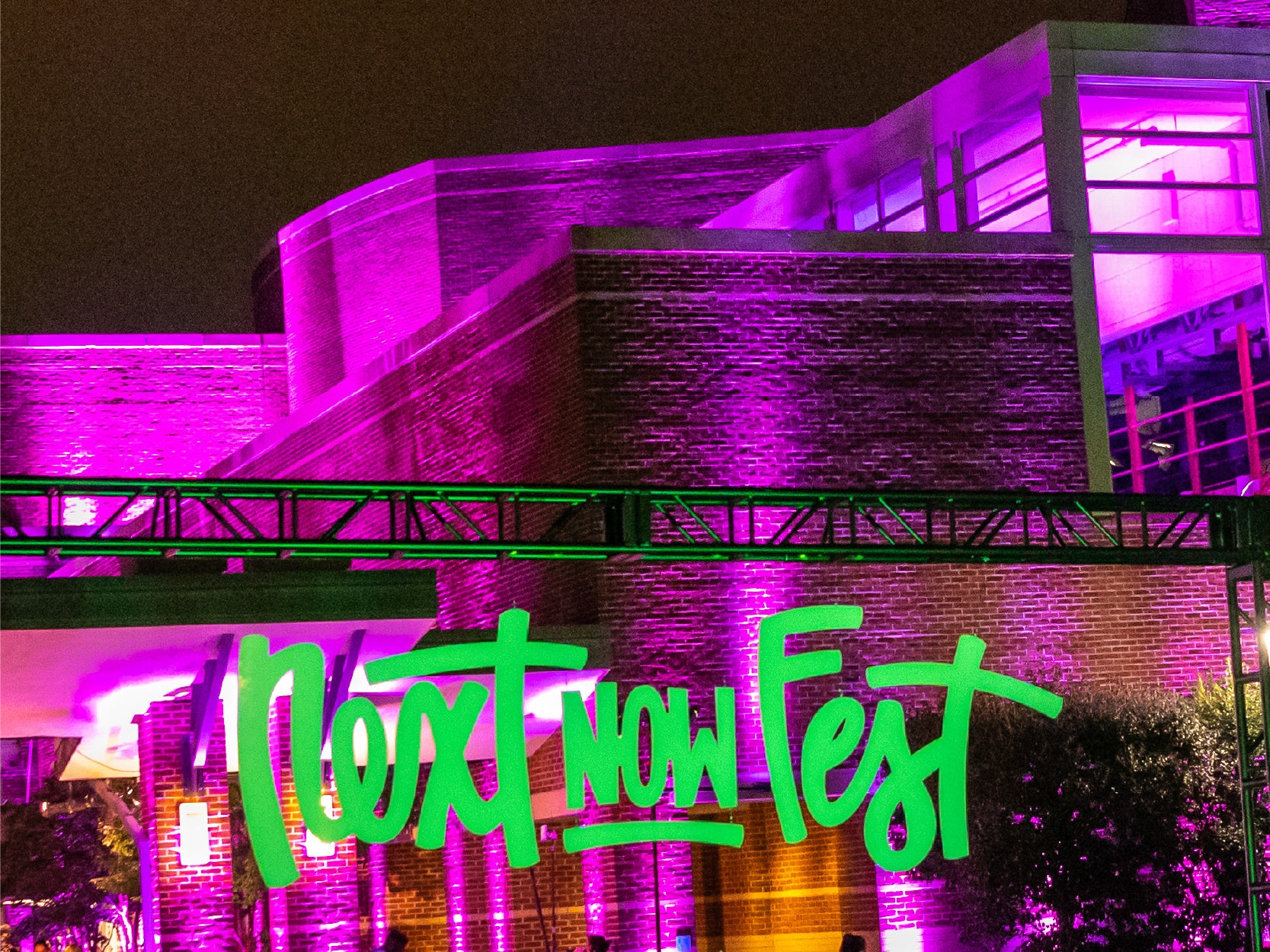 The facade of UMD's The Clarice lit up purple, with bright "NextNOW Fest" signage