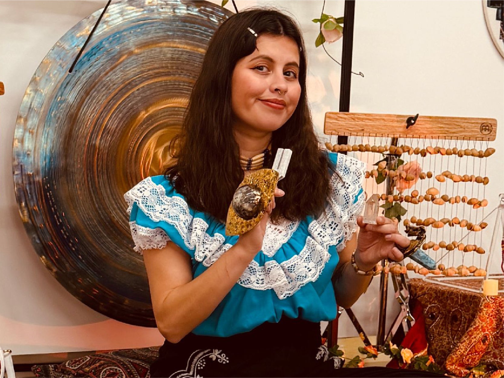 artist and sound healing practitioner Estephanie Rose holds a tuning fork and a clear crystal.