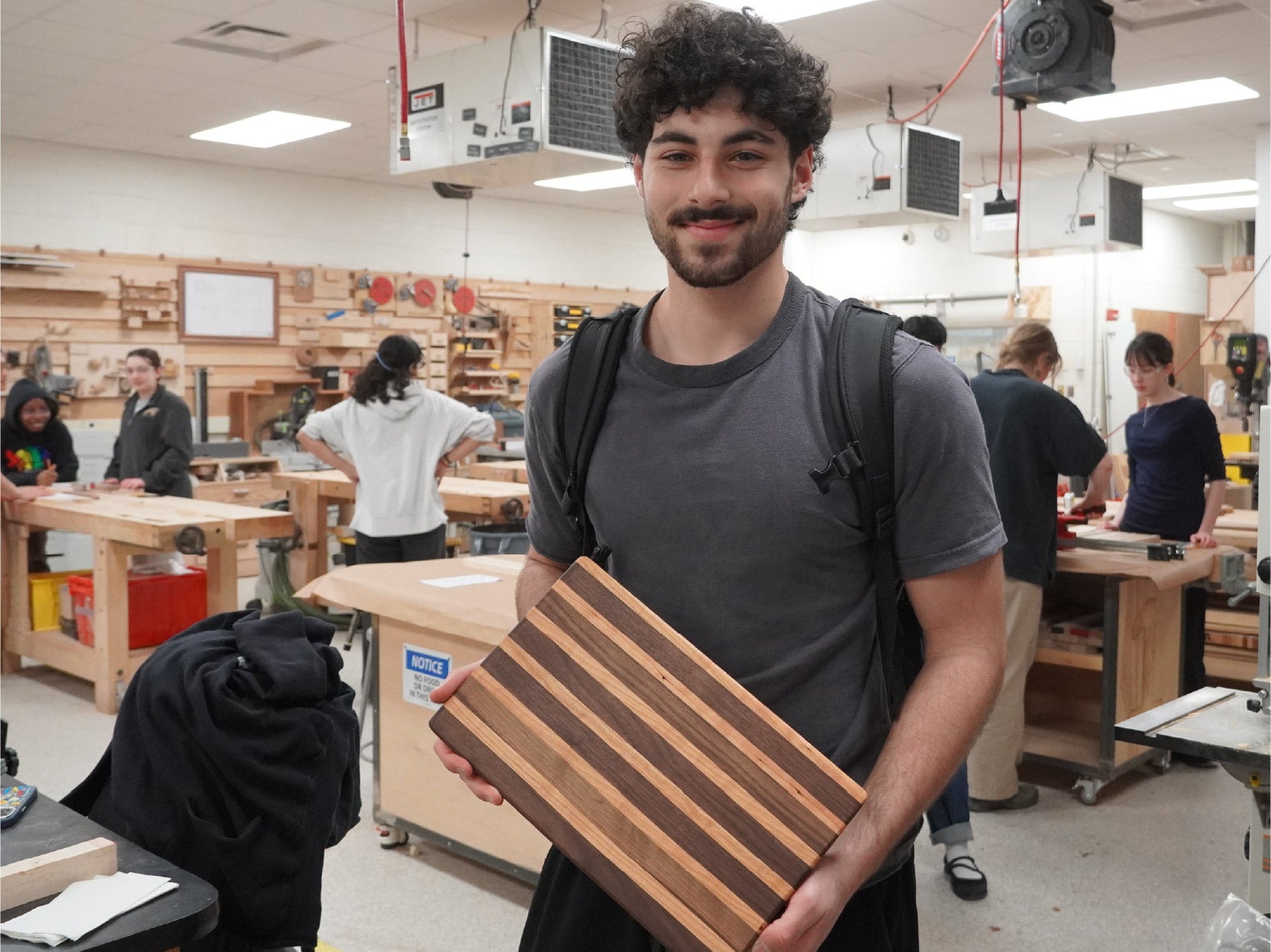 A photo of a student holding a cutting board made at a past terrapin works workshop event.