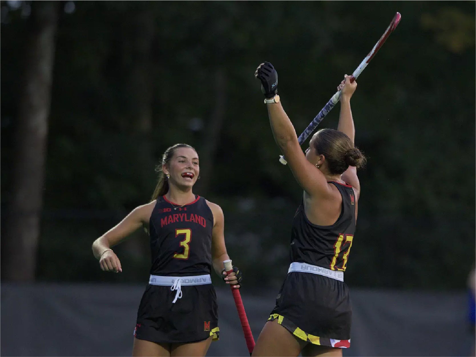 A photo of 2 UMD Field Hockey players during a game.
