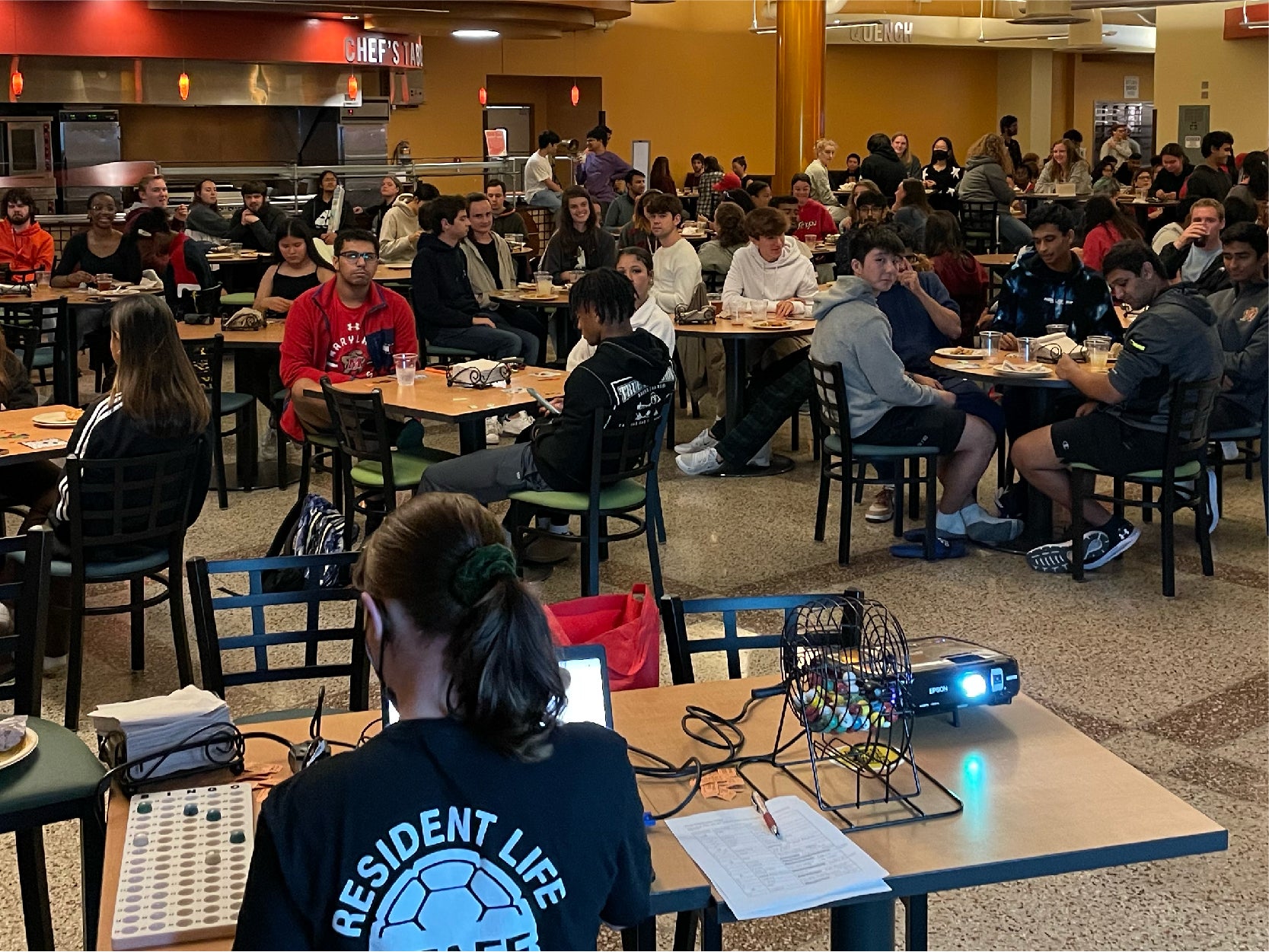 A photo of a arge group of students playing BINGO in a UMD dining hall.